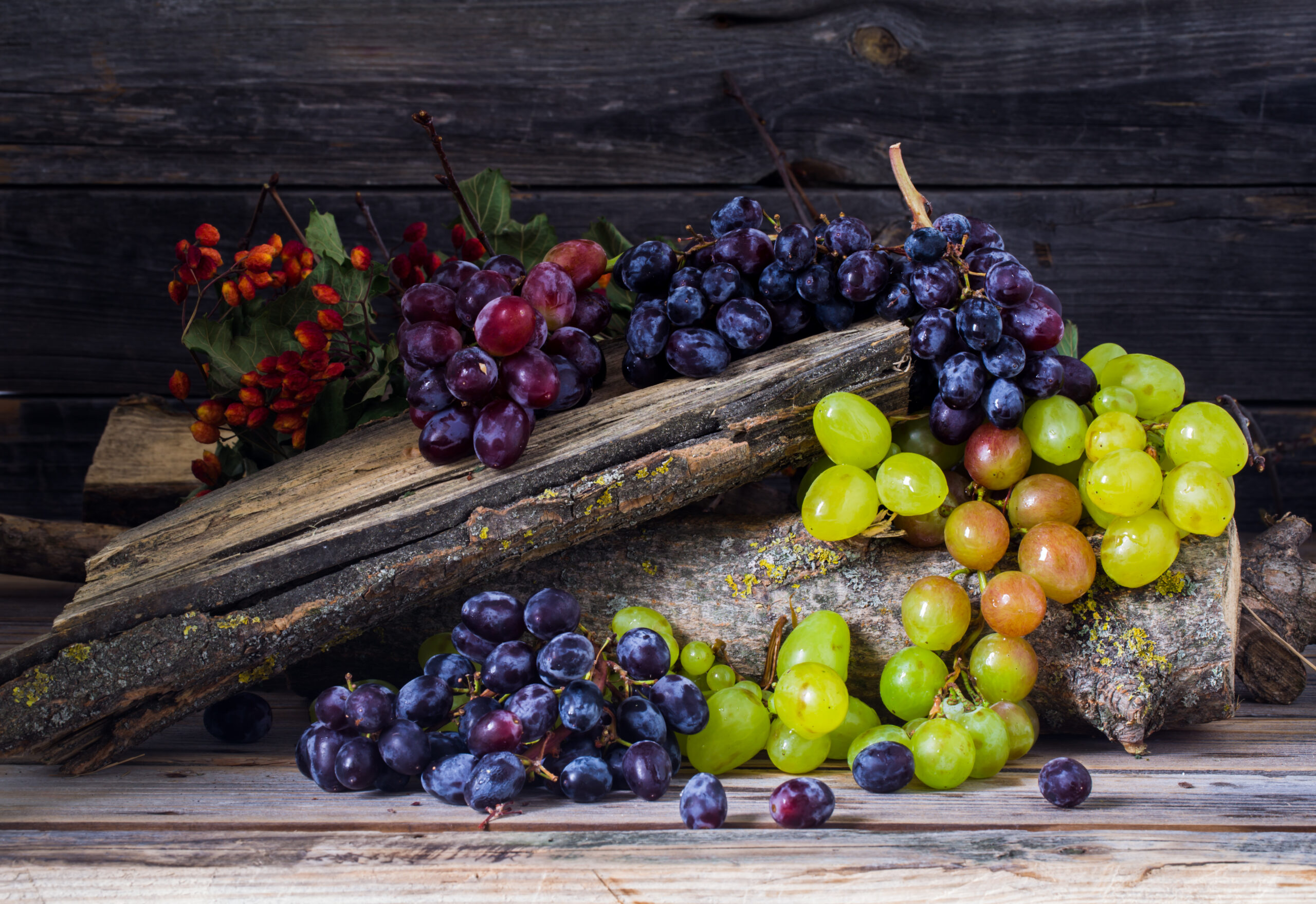 a sprig of grapes on wooden background, delicious fruit